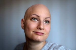 Tiia Valkeapää istuu sohvan reunalla ja katsoo ulos ikkunasta.