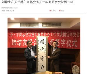 Liu Deshen, lokal ledare för Enhetsfronten i staden Changchun besökte Erlin Yang i Helsingfors år 2017. Två personer poserar med en text på kinesiska.