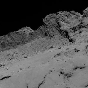 Lähikuva 67P/Churyumov-Gerasimenkon pinnasta. Pinta on oikeasti hyvin tumma Lähikuva komeetan ytimen pinnasta