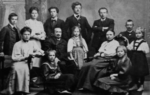 Kuva Raition suurperheestä noin vuodelta 1904–1906. Väinö Raitio seisoo äärimmäisenä vasemmalla. Viulistiveli Eino Raitio seisoo kädet puuskassa äidin takana. Säveltäjä Väinö Raition lapsuuden perhe noin vuonna 1904–1906.
