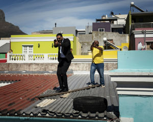 Kaksi miestä astelee katolla aseet kädessään.