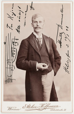 Korskeaviiksinen viulutaiteilija Willy Burmester omisti valokuvansa rva Kajanukselle maaliskuussa 1898. Viulutaiteilija Willy Burmester 1890-luvun ateljee-kuvassa. Omistuskirjoitus rva Kajanukselle 12.3.1898.