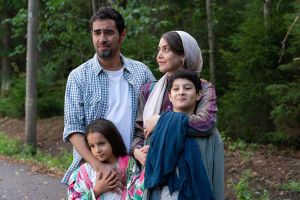 Shahab Hosseini, Kimiya Eskandari, Shabnam Ghorbani ja Aran-Sina Keshvari Ensilumi-elokuvassa. Familjen Mehdipour står i en klunga och väntar på bussen.