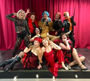 Aistikkaat: takarivi (vas.) Naked Snake, Clary Strass, Lola Want, Badass Grandma, Marley Davidson, eturivi (vas.) Ana De Conda, Dainty, Lady Butterfly, keskellä Jaana Pirskanen Burleskiryhmä Aistikkaat poseeraa yhdessä teatterin lavalla