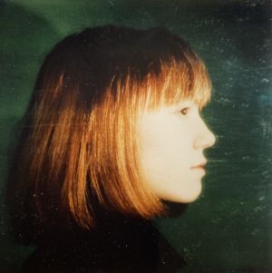 Kuvataiteilija Olli Lyytikäinen otti tuohon aikaan uudenaikaisella polaroidkamerallaan tämän kuvan Annette Arlanderista erään illanvieton yhteydessä luultavasti vuonna 1975. Annette Arlander sivukuvassa, oranssinruskea polkkatukka ja vihreä tausta.