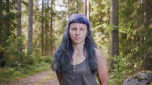 Käsityötaiteilija Elena Bondar lähikuvassa. Taustalla näkyy metsää.