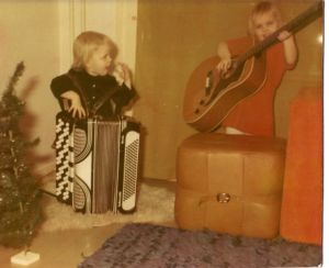 Anita (vas.) ja Irene mummon tekemissä samettimekoissa Pyhäniemessä isän luona vuonna 1972. Kaksi vuotta Anitaa vanhempi Irene soittaa isän uutta, 12-kielistä kitaraa. Anita ei vielä jaksa nostaa harmonikkaa syliin. Anita ja Irene lapsina soittamassa harmonikkaa ja kitaraa.