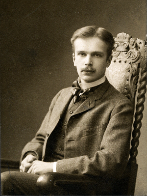 Kosti Vehanen Rooman opintojen aikoihin 1910. Kosti Vehanen istuu korkeaselkäisessä nojatuolissa valokuvaamossa.