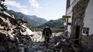Brandman går igenom ruiner i Arquato del Tronto.