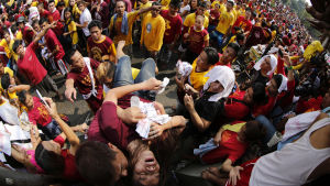 Pilgrimer bär på en medvetslös kvinna Filippinska pilgrimer bär på en medvetslös kvinna under Black Nazarene-processionen i Manila 9.1.2016