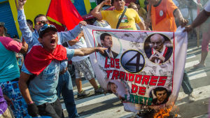 Aktivister bränner flaggor med bilder av politiker i Peru som anklagas för att förrått ursprungsfolket i Loreto eftersom de tillät privata oljebolag i området Aktivister bränner flaggor med bilder av politiker i Peru som anklagas för att förrått ursprungsfolket i Loreto eftersom de tillät privata oljebolag i området