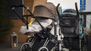 Familjearbetaren går ut en stund med barnen. Kahdet lastenrattaat ulkona