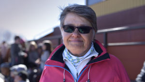 Rektor Inger Nabb på Vikinga skola i Vasa säger att de är beredda på att familjer inte satsar på skidutrustning. en kvinna med solglasögon och sportiga kläder ser mot kameran i publikläktaren på en idrottsbana