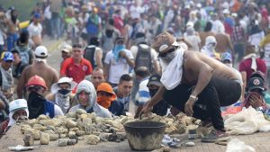 Demonstrant gör sig redo att kasta sten mot regeringslojala styrkor. En demonstrant gör sig redo att kasta sten under sammandrabbningarna med säkerhetsstyrkorna vid gränsen mellan Venzuela och Colombia.