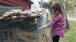 Sabina var vad vid att ta hand om andra (som de här kaninerna hon sköter om i väntan på ett nytt hem) men hade svårt att acceptera att hon själv var sjuk. Sabina Granbacka står framför en kaninbur.