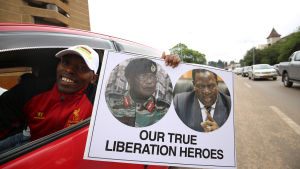 "Våra verkliga befrielsehjältar" står det på den här demonstrantens plakat. Fotografierna på plakatet visar arméchefen Constantino Chiwenga och den avsatte vicepresidenten Emmerson Mnangagwa. "Våra verkliga befrielsehjältar" står det på den här demonstrantens plakat. Fotografierna på plakatet visar arméchefen Constantino Chiwenga och den avsatte vicepresidenten Emmerson Mnangagwa.