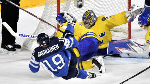 Henrik Lundqvist räddar ett skott av en fallande Veli-Matti Savinainen.