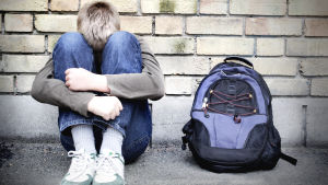 Förra året fick Rädda Barnen i Finland in dryga femtio tips per vecka om misstänkt material av sexuell exponering av barn. Nu under de senaste veckorna har detta ökat med cirka 70 till 200 tips per vecka. En pojke sitter med huvudet i famnen.