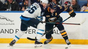 Mark Scheifele och Rasmus Ristolainen kämpar om pucken. Mark Scheifele och Rasmus Ristolainen kämpar om pucken.
