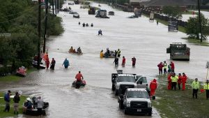 Människor lämnar sina hem i ett översvämmat bostadsområde i Houston. Människor lämnar sina hem i ett översvämmat bostadsområde i Houston.