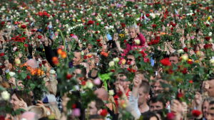 Rosentåg i Olso den 25 juli 2011. Ett människohav som står och håller upp rosor i luften.