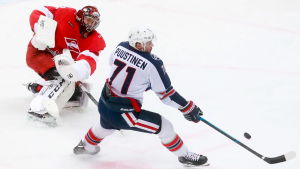 Juuso Puustinen fortsätter i Ryssland. Juuso Puustinen försöker nå en puck framför motståndarmålvakten.