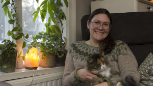 Nu när Sandra fått sin diagnos fungerar vardagen bättre. En kvinna sitter i en fåtölj. I famnen har hon en katt.