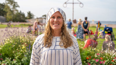 En kvinna iklädd randig pyjamasdräkt med en tomteliknande luva i samma tyg.