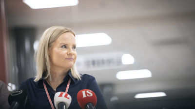 riikka purra tiedotustilaisuudessa, mikrofoneja edustalla