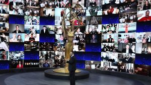 På plats i Los Angeles fanns bara Kimmel och en stor skärm. Bild på programledaren för Emmygalan. Står på en scen omringad av en skärm med massa små bilder på personer som är med live.