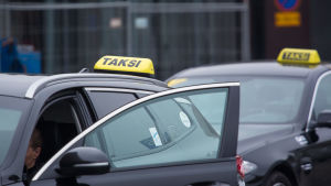 Två taxibilar står och väntar på nya kunder.