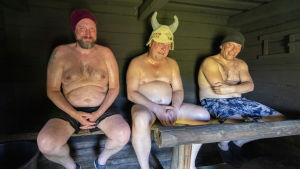 Bastuns roll i att Finland är ett av världens lyckligaste länder ska inte underskattas, säger Finlands bastusällskap. Kolme miestä savusaunan lauteilla.