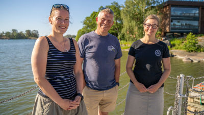Camilla Gustafsson, Alf Norkko och Joanna Norkko står på en brygga vid havet framför Tvärminne zoologiska station.