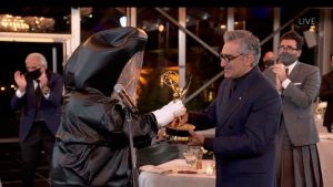 Eugene Levy tog emot sin Emmystatyett av en prisutdelare som klätt sig i en heltäckande kostym för att minimera smittorisken för coronaviruset. Eugene Levy tar emot sin Emmystatyett av en prisutdelare som klätt in i en heltäckande kostym för att minimera smittorisk för coronaviruset.