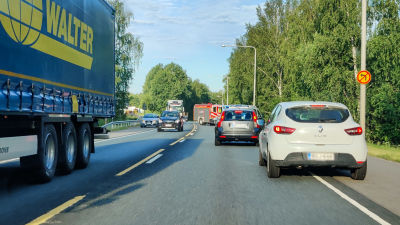Flera bilar passerar en brandbil som står snett över vägen.