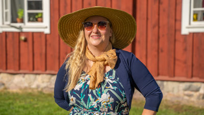 Kvinna framför ett hus.