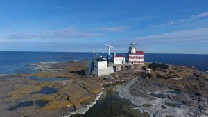 Märkets fyr har sett tiotals haverier i 134 år där den står på den låga klippan på Ålands hav. Bild på en fyr på en ö.