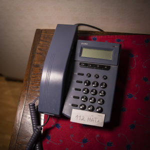 Puhelin, johon on merkitty lapulla hätänumero. 