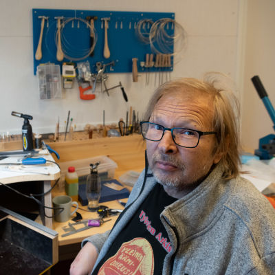 En man sitter i ett rum.