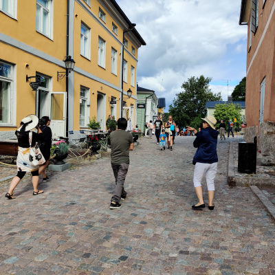 Folk som promenerar på en gågata en sommardag.