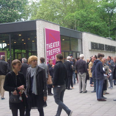Theatertreffens hemmascen finns i Berlins Festspelhus. I publikvimlet inför ännu en föreställning råkar Theatertreffen-chefen Yvonne Büdenhölzer fastna på bild, hon står längst fram till höger.