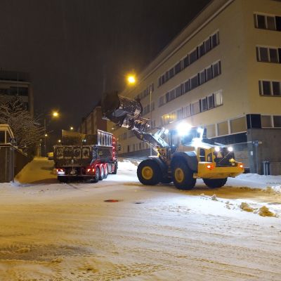 Lunta poistetaan kadun varresta Kuopiossa aamuyöllä.