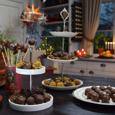 Ett bord dukat med olika julgodis, chokladpraliner och cake-pops - en sorts småkaka på pinne.