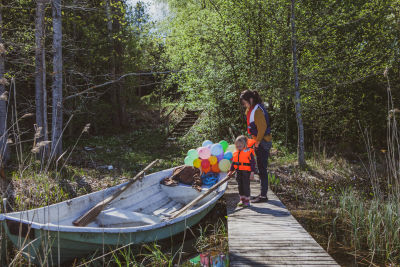 Äiti ja lapsi lähdössä veneretkelle. Mukana paljon ilmapalloja.