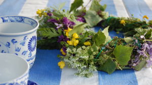 En blomsterkrans på ett bord med två koppar.