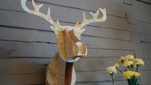 Kartongista tehty peuran pää Strömsön huvilan seinällä.