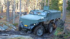 Misun kan ta sig fram i skog och mark. Pansarfordonet Misu framifrån då det kör i somrig skogsterräng vid en bergsfot.
