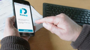 Vem sitter här? Kodernas ägare eller någon annan? Mobiltelefon och händer ovanför ett tangentbord.