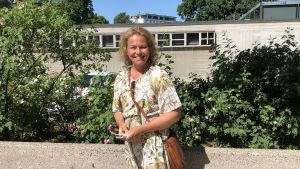 Micaela Lillkung säger att tobaksrök kan vara jobbigt ifall det sprider sig till andra lägenheter. Micaela Lillkung framför rosenbuskar vid Biskopsgatan i Åbo.