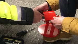 Kuvassa asennetaan kiinetistöön asennettavaa laitetta.